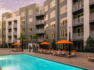 a pool with chairs and umbrellas in front of a building at Milpitas 1BR w Pool Gym WD nr BART SFO-747 in Milpitas