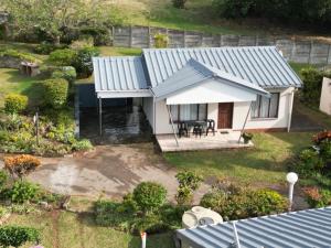 an aerial view of a small house with a blue roof at Neptune corner in Hibberdene