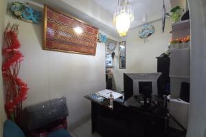 a room with a desk and a computer on a wall at OYO Life 93023 Kost Bulan Karawang in Karawang