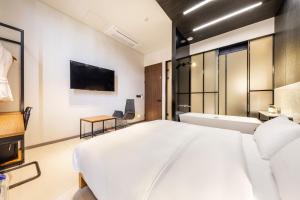 a bedroom with a large white bed and a tv at Hotel The Artist Yeonsinnae in Seoul