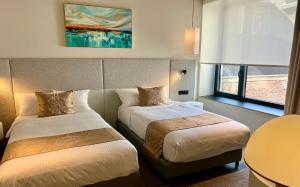 a hotel room with two beds and a table at OPO Hotel in Brussels