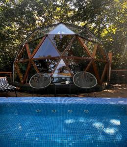 a tent with a table and chairs next to a pool at Glamping Martini Kvariati in Batumi