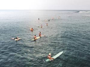 een groep mensen op surfplanken in het water bij Pacifico Surf Bayay 