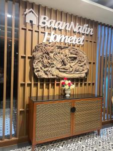 a store front with a sign on a wooden wall at Baannalin Hometel บ้านนลิน โฮมเทล in Chiang Mai