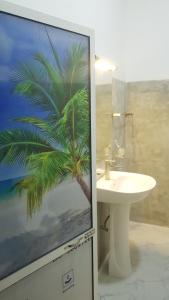 a bathroom with a picture of a palm tree at Kabalana Ocean Blue in Ahangama