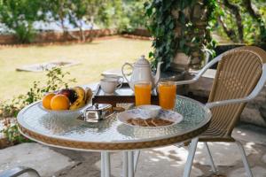 une table avec un plateau de fruits et deux verres de jus d'orange dans l'établissement SaffronStays The Clairmont Cottage,Mukteshwar, à Mukteswar