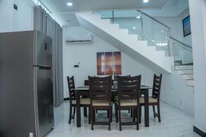 a dining room with a table and chairs and stairs at Florence Villas in Jaffna
