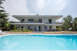 a large house with a swimming pool in front of it at Villa Sergio in Bardolino