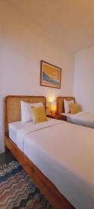 a bedroom with two beds and a couch at Betah Homestay Banyuwangi in Banyuwangi