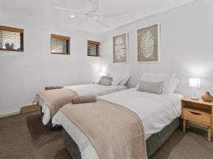 2 camas en un dormitorio con paredes blancas en Pier One Waterfront Apartment, en Urangan 10 fotos más