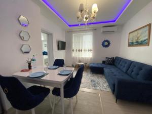 a living room with a table and a blue couch at Bluemoon-Apartment with Parking in Burgas