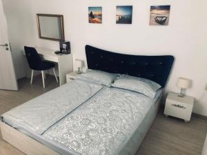 a bedroom with a bed and a desk with a chair at Bluemoon-Apartment with Parking in Burgas
