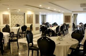 um salão de banquetes com mesas e cadeiras com toalha de mesa branca em Burgaz İzer Hotel em Lüleburgaz