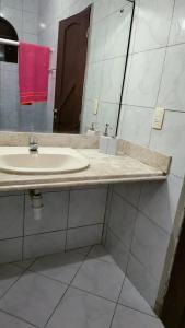 La salle de bains est pourvue d'un lavabo et d'un miroir. dans l'établissement Casa Frida 3, à Natal
