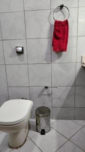 La salle de bains est pourvue de toilettes et d'une serviette rouge. dans l'établissement Casa Frida 3, à Natal