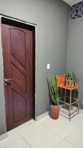 a door in a room with a table and a plant at Casa Frida 3 in Natal