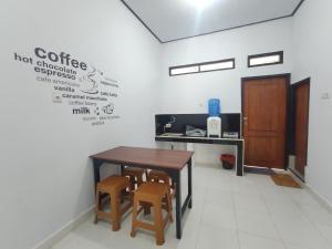 een kantoor met een tafel en twee stoelen en een bureau bij Home Syariah Guest House Ampana in Dondo