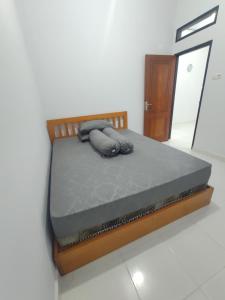 Home Syariah Guest House Ampana في Dondo: سرير في غرفة ذات اطار خشبي