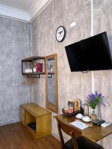 a living room with a table and a flat screen tv at Amy Hostel Hue in Hue