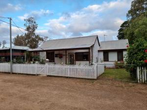 a white house with a white picket fence at Rose Cottage Nannup in Nannup