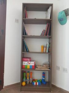 een boekenplank met boeken en speelgoed erop bij Arsinoe Guest House in Famagusta