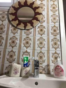 een wastafel met een spiegel en toiletartikelen erop bij Arsinoe Guest House in Famagusta
