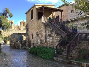 een oud stenen gebouw met een trap erop bij Arsinoe Guest House in Famagusta