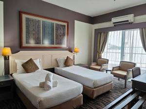 a hotel room with two beds and a living room at Seaview Deluxe@Rainbow Paradise Tg Bungah 4pax in Tanjung Bungah