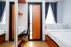 ein Schlafzimmer mit einem Bett, einem Schreibtisch und einem Stuhl in der Unterkunft RedLiving Syariah Apartemen MKostel - Tower A1 Kencana Loka in Rancalutung + 19 Fotos