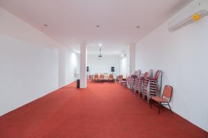 une pièce vide avec des chaises et un tapis rouge dans l'établissement RedLiving Syariah Apartemen MKostel - Tower A1 Kencana Loka, 
