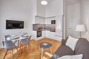 a living room with a couch and a table with chairs at DownTown Suites Rubesova in Prague
