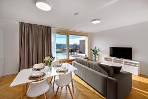 a living room with a table and a couch at DownTown Suites Rubesova in Prague