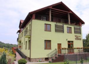 a large yellow building with a sign on it at Villa Valle Verde in Stronie Śląskie