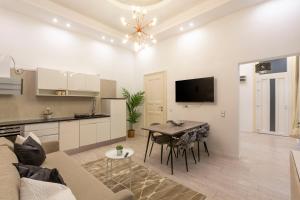 Deluxe Izabella Apartment in the Center of Budapest في بودابست: مطبخ وغرفة معيشة مع طاولة وأريكة