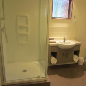 a bathroom with a shower and a sink at The Hobbit Motorlodge in Ohakune