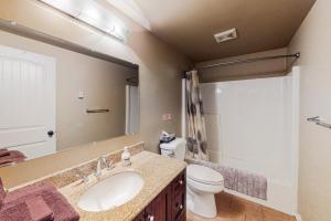 een badkamer met een wastafel, een toilet en een spiegel bij Lac Le Jeune at Cabin 29 and 30 in Kamloops