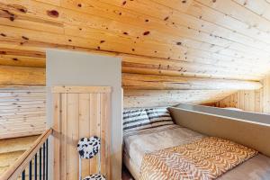 Cama en habitación con techo de madera en Lac Le Jeune at Cabin 29 and 30 en Kamloops