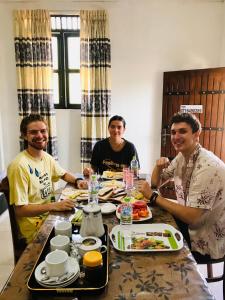 Eine Gruppe von Menschen, die an einem Tisch sitzen und Essen essen. in der Unterkunft Dambulla Tourist Resort in Dambulla