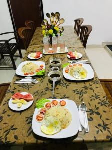a table with plates of food on it at Dambulla Tourist Resort in Dambulla