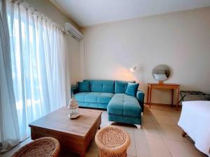a living room with a blue couch and a table at Annamaria Sea Side View Studio- 25m From The Beac in Plakias