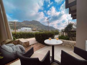 a patio with a table and two glasses of wine at Annamaria Sea Side View Studio- 25m From The Beac in Plakias