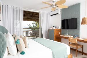 a bedroom with a bed and a desk and a television at Seapoint Boutique Hotel in Pointe aux Cannoniers