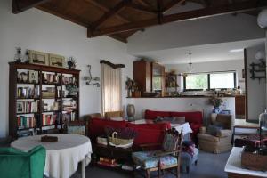 Casa rural La Liñana في قرطبة: غرفة معيشة مع أريكة حمراء وطاولة