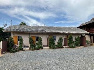 uma casa com um monte de árvores na frente dela em บ้านพระพร@ขุนยวม 