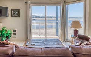 a living room with a couch and a view of the beach at Dock of The Bay #203 in Lincoln City