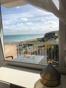 einen Balkon mit einem Tisch und Meerblick in der Unterkunft T2 Vue MER COSY HORIZON PLAGE in Plérin