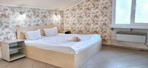 un osito de peluche sentado en una cama en un dormitorio en Lisova - Лісова готельня і сауна, en Kiev