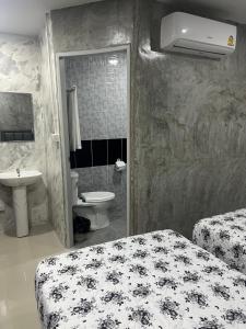 baño con 2 camas, lavabo y aseo en คาเฟ่ เดอ แจ่วบอง รูมแอนด์เซอร์วิส, en Khon Kaen