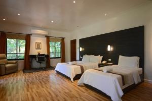 ein Hotelzimmer mit 2 Betten und einem TV in der Unterkunft Bellagio Hills Hotel and Restaurant in Paoay