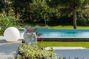 una piscina en un patio con terraza de madera en SKARPA resort en Ustronie Morskie